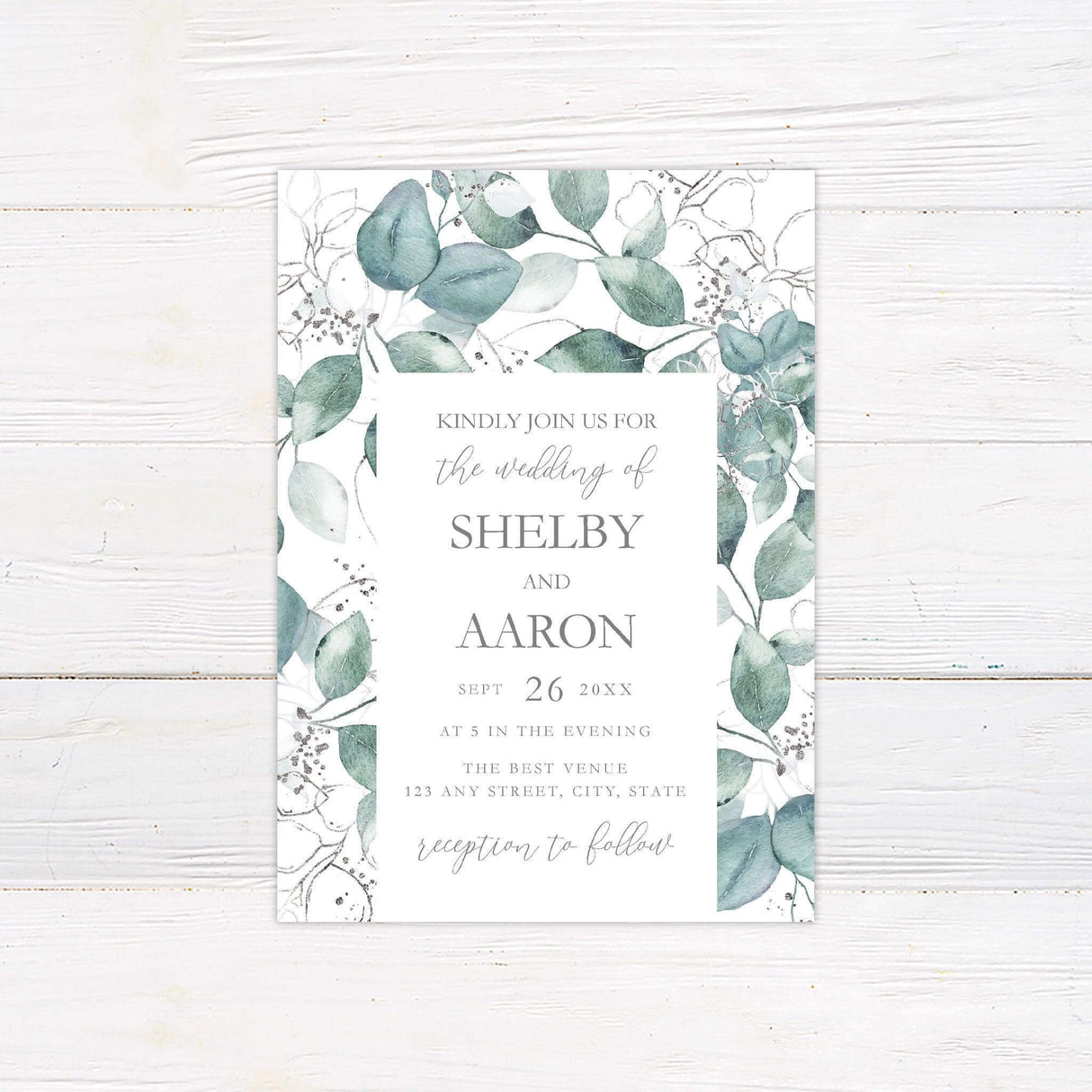 Watercolor eucalyptus wedding invitation with silver botanical details and minimalist fonts, printed on white background