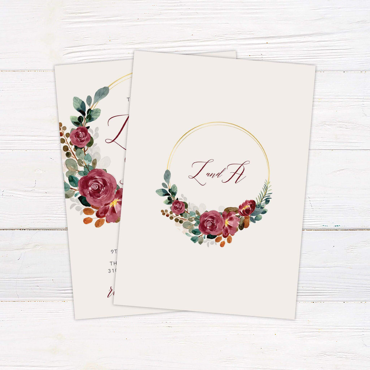 Wedding invitation with burgundy floral watercolor wreath, gold arc detail, and elegant script and serif text on a cream background - back