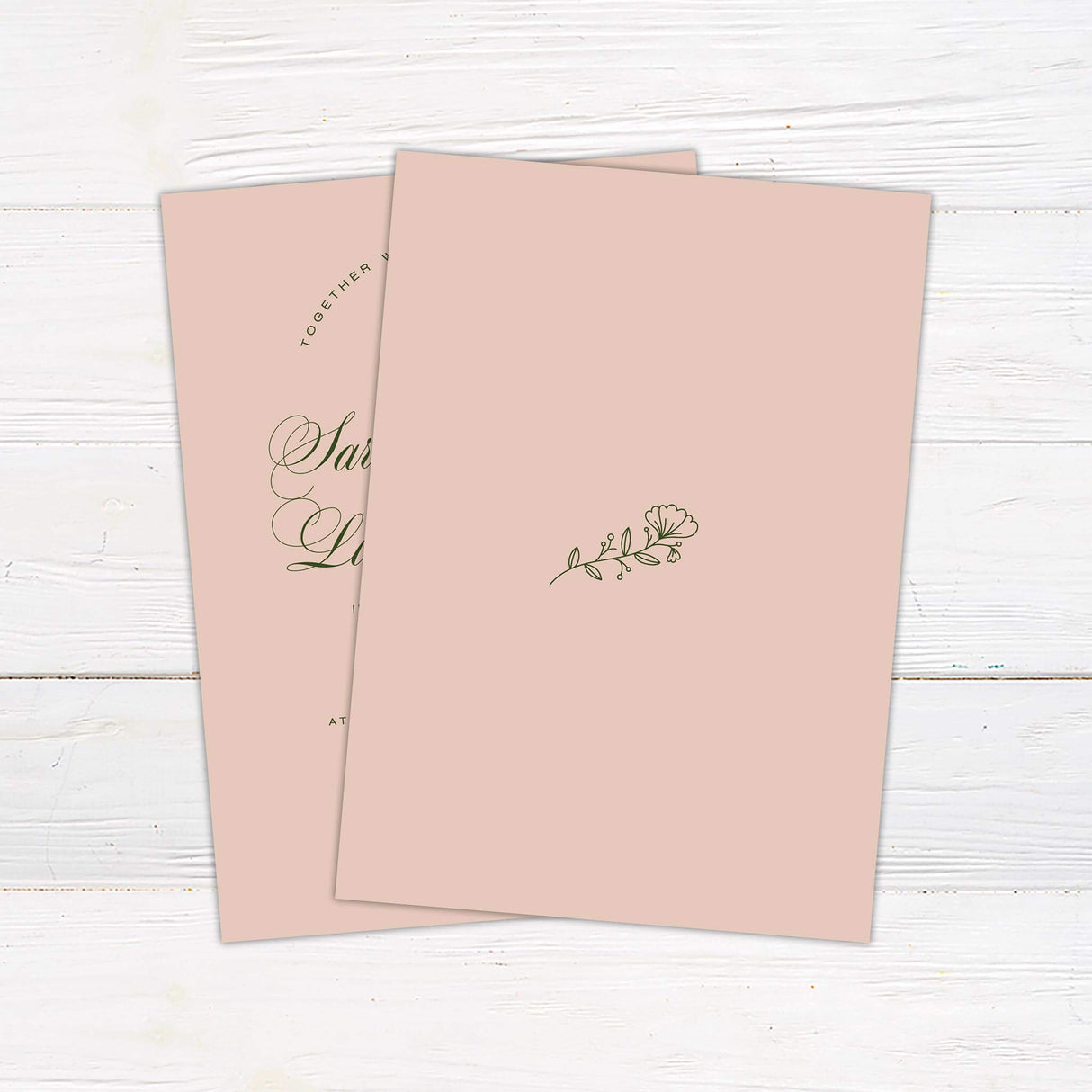 Blush pink wedding invitation with elegant green script font, minimal floral accent, and classic layout. Back