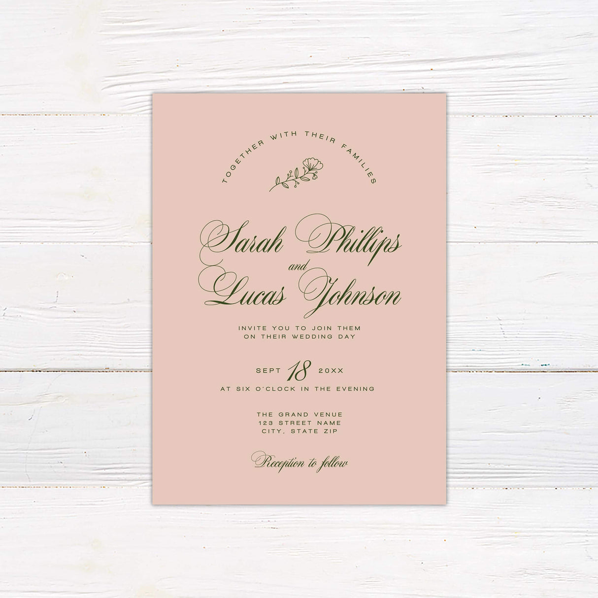 Blush pink wedding invitation with elegant green script font, minimal floral accent, and classic layout.