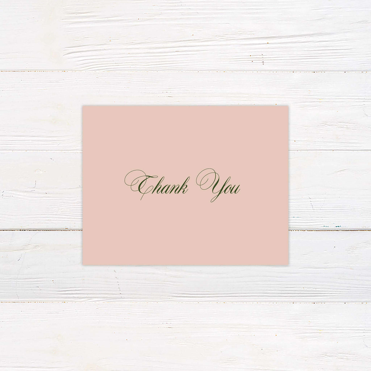 Blush pink thank you card with elegant green script font, minimal floral accent, and classic layout.
