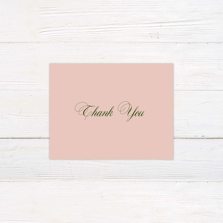 Blush pink thank you card with elegant green script font, minimal floral accent, and classic layout.