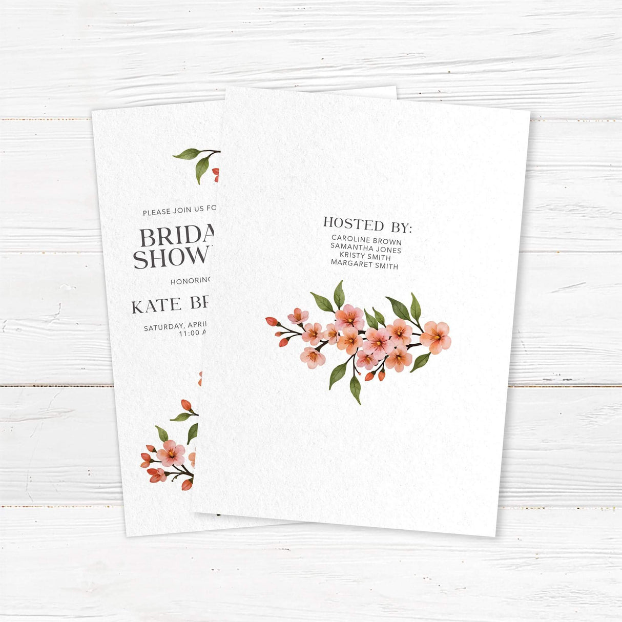 Bridal shower invitation featuring a watercolor cherry blossom vine with soft pink flowers and green leaves, printed on premium cardstock. Back