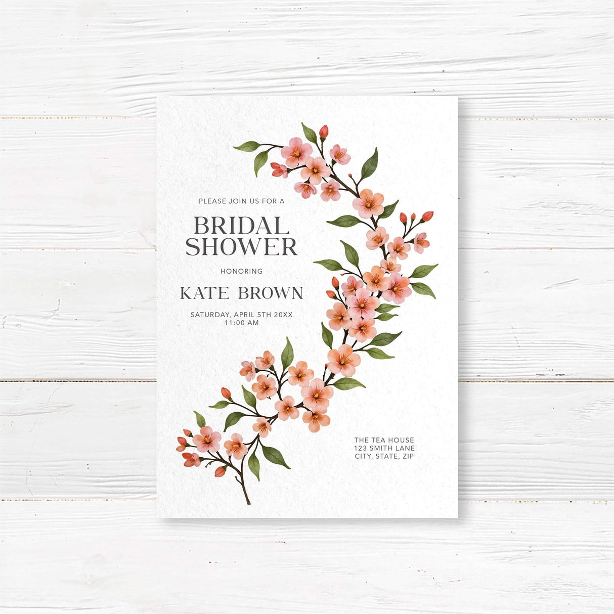 Bridal shower invitation featuring a watercolor cherry blossom vine with soft pink flowers and green leaves, printed on premium cardstock.