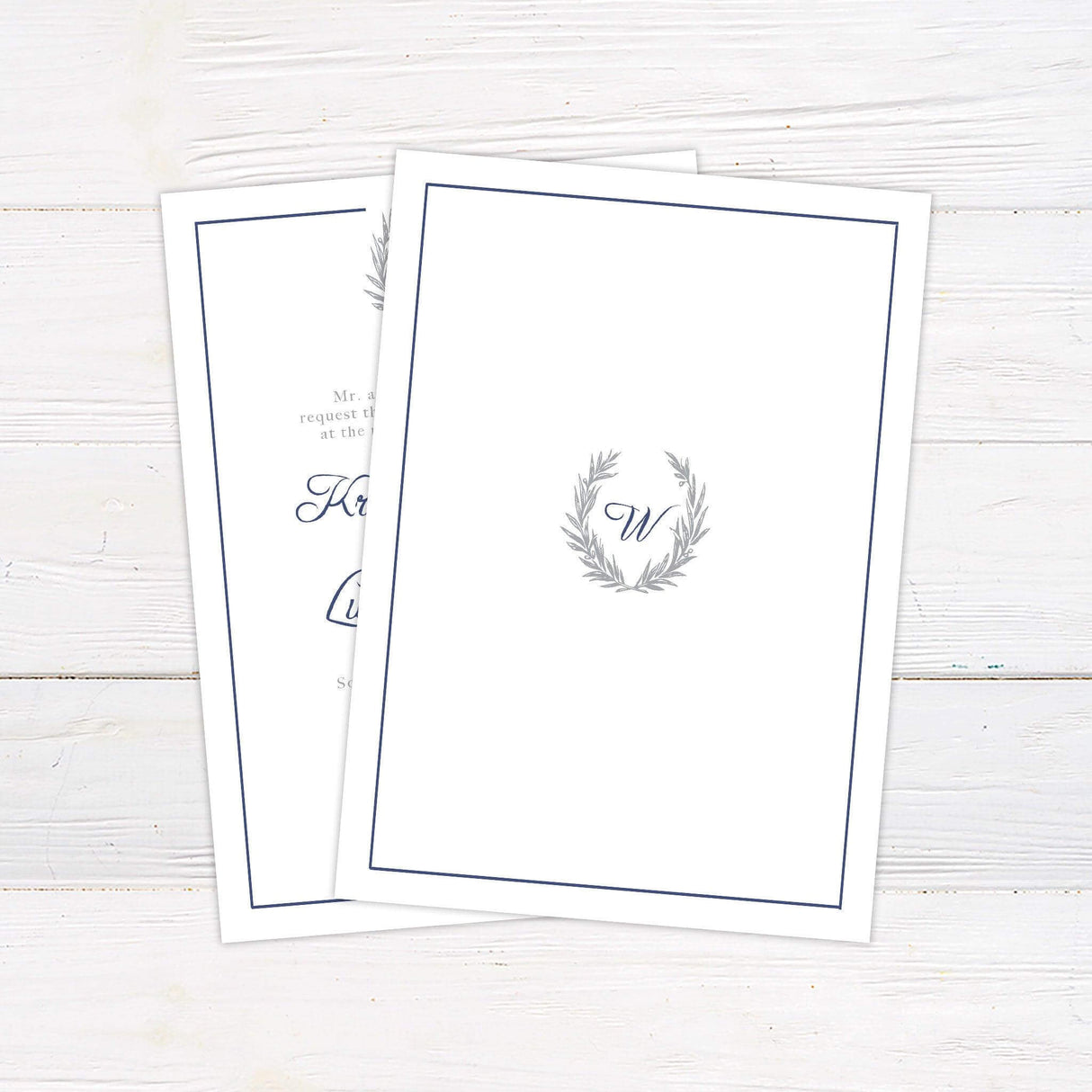 Formal wedding invitation with monogram laurel crest, script and serif fonts, and a classic border in navy and gray tones - back