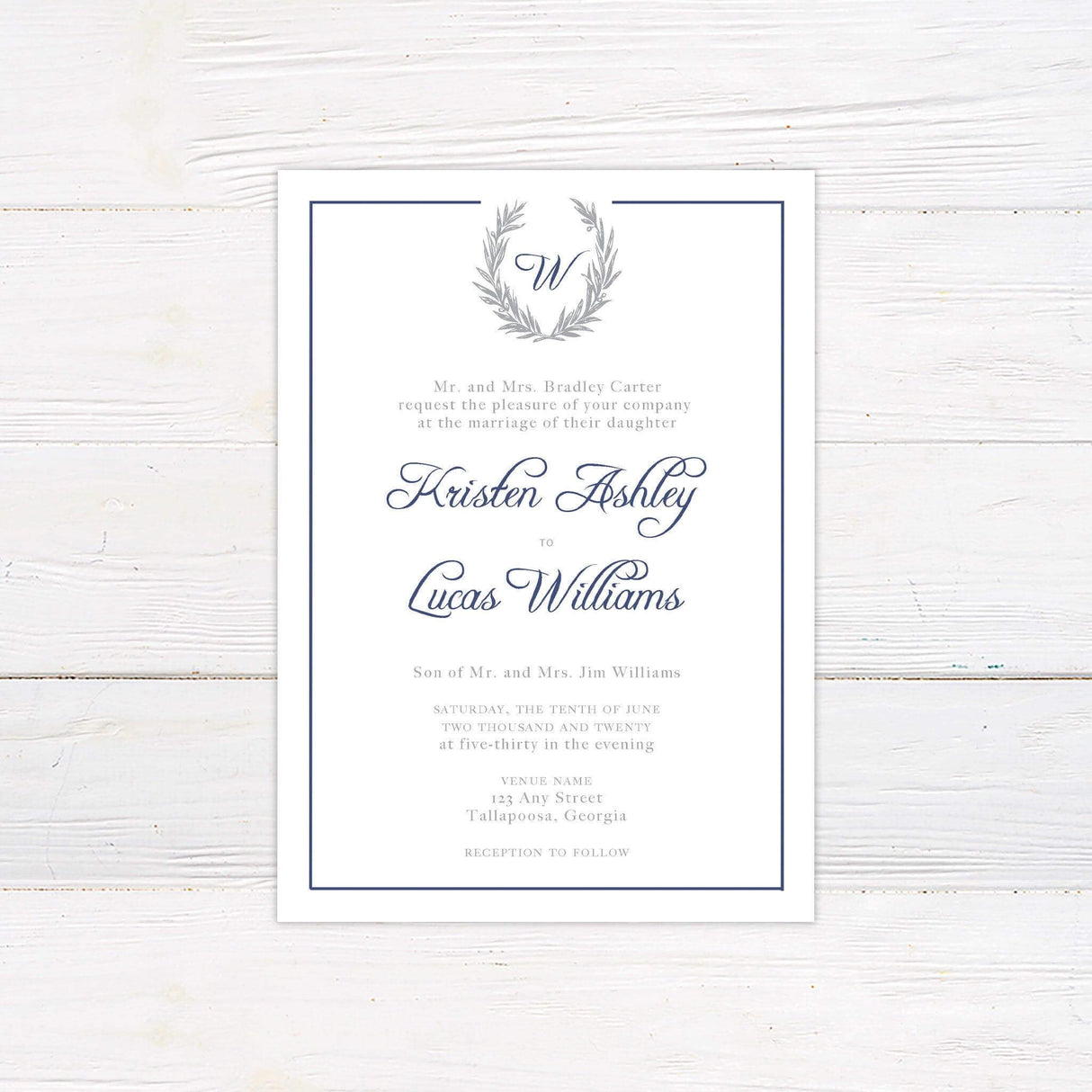 Formal wedding invitation with monogram laurel crest, script and serif fonts, and a classic border in navy and gray tones