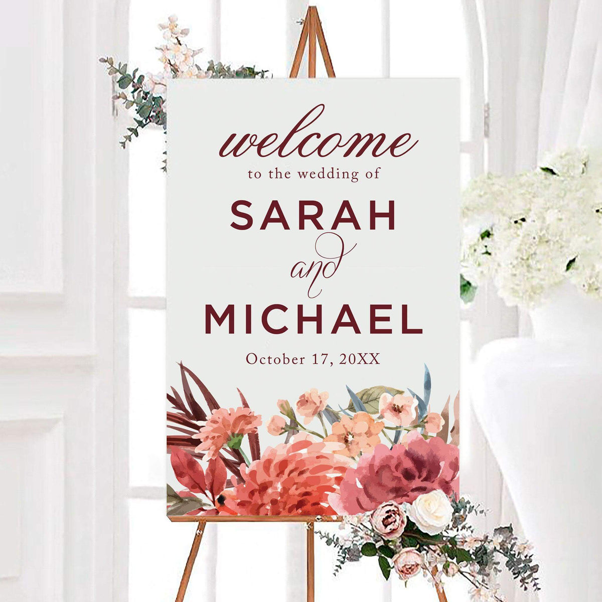 Personalized fresh blooms wedding welcome sign with pink, coral, and burgundy watercolor flowers along the bottom. Elegant lettering displays the couple’s names and wedding date.