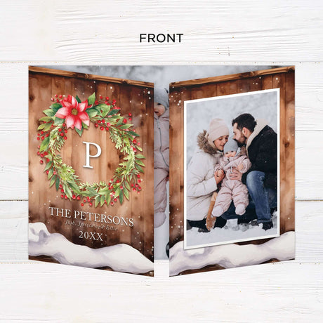 This gatefold holiday card features a cozy woodgrain background with a snow-dusted edge and watercolor floral wreath. Inside, it displays framed photos, festive typography with “Wishing You a Merry Christmas and a Happy New Year,” and a monogram accent. - front.