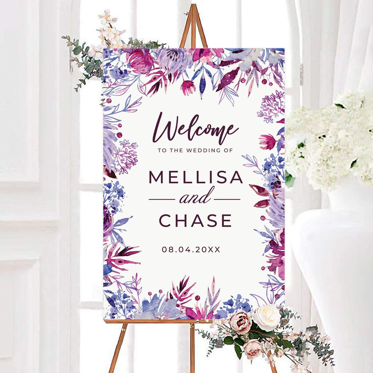 Personalized fuchsia frenzy wedding welcome sign surrounded by vibrant watercolor flowers in pink, purple, and blue. Elegant lettering displays custom names and a wedding date.