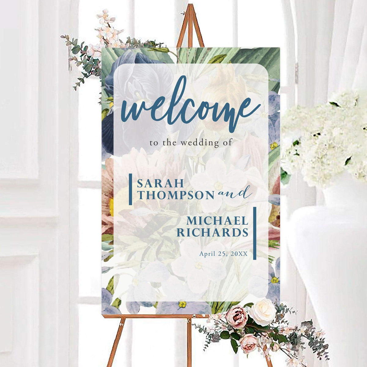 Personalized full floral wedding welcome sign featuring a full floral background with soft flowers and greenery. Custom names and wedding date appear inside a light center panel.