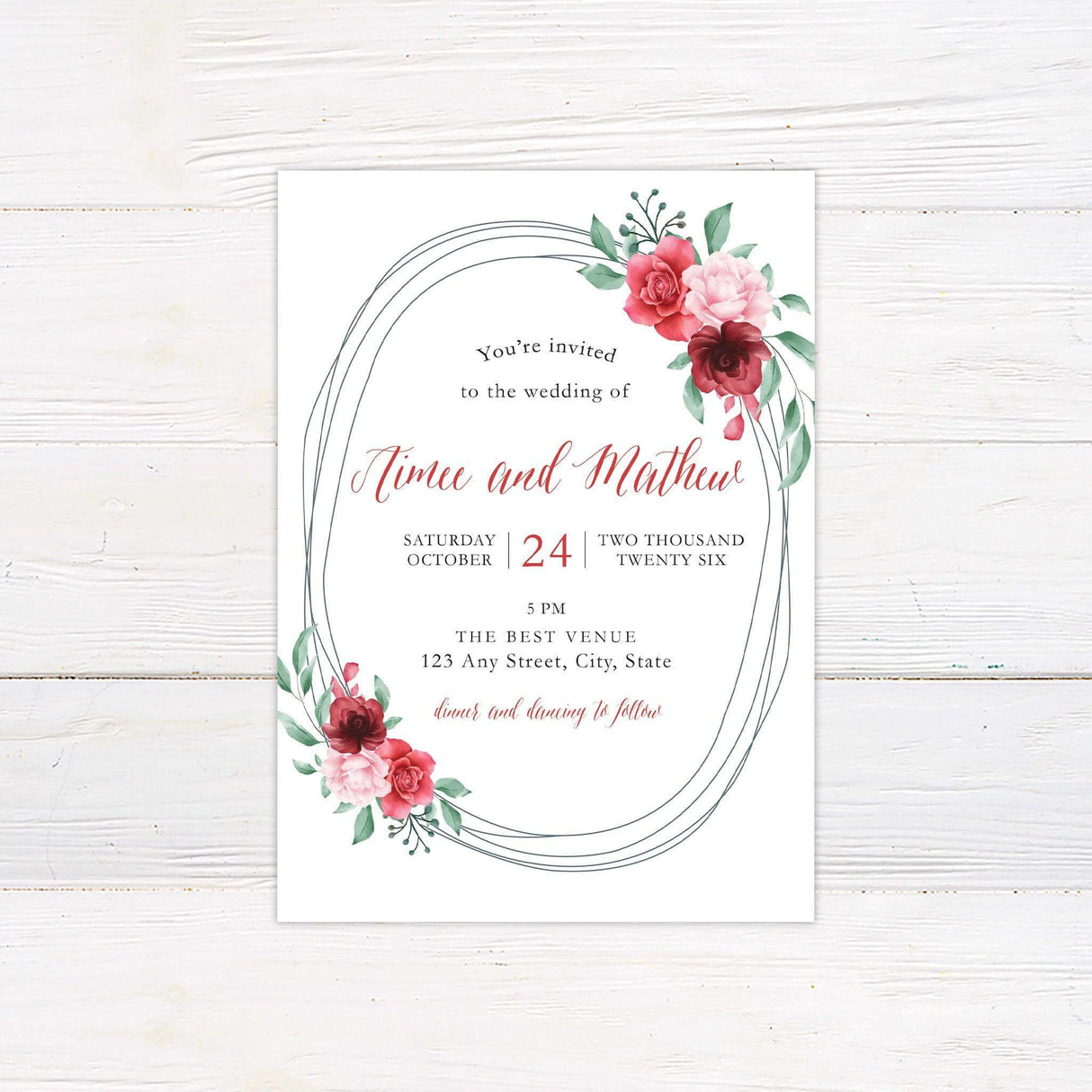 Printed garden-themed wedding invitation with blush and burgundy floral wreath and elegant calligraphy
