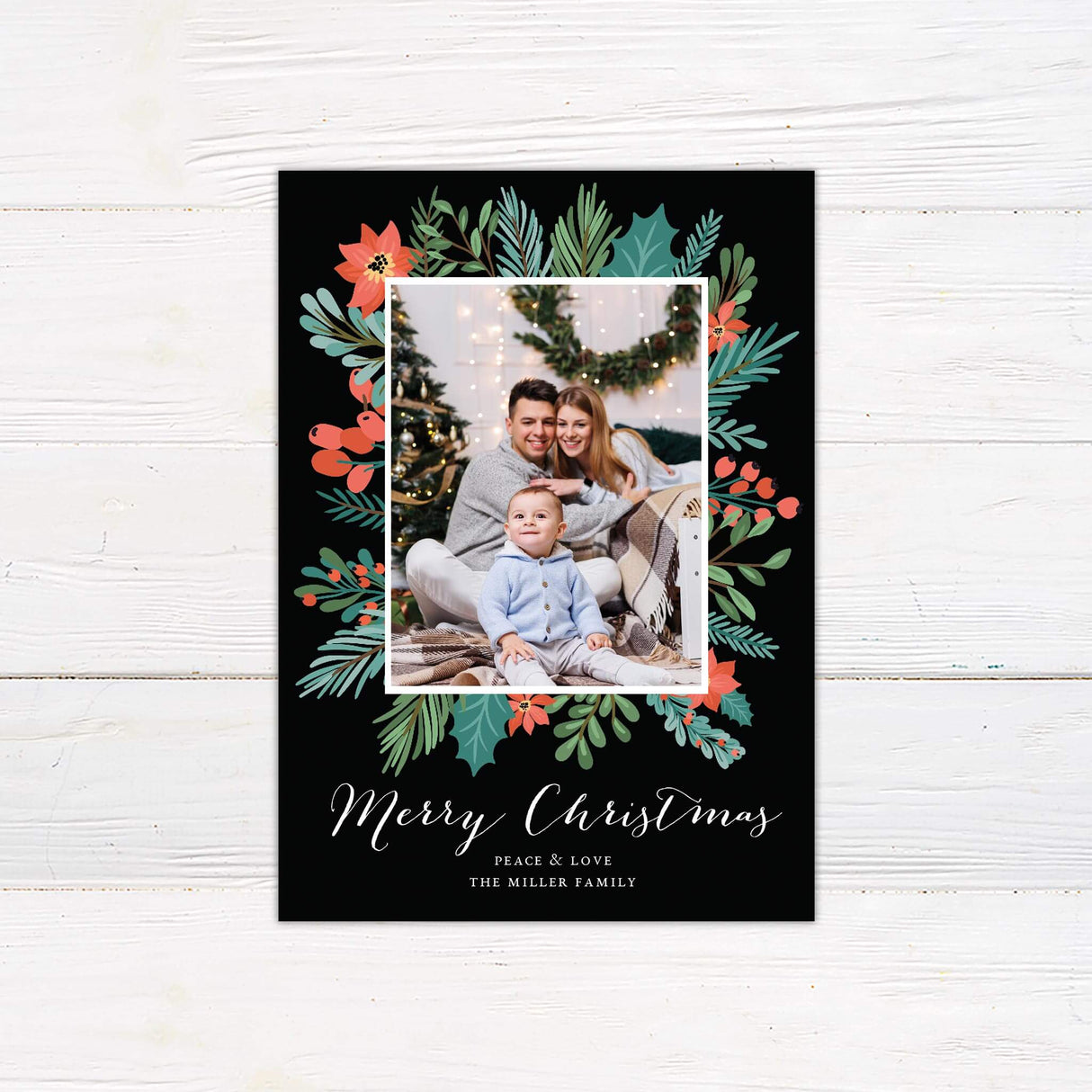 Custom family photo Christmas card with botanical greenery and berries on a charcoal background, featuring “Merry Christmas” and a framed image