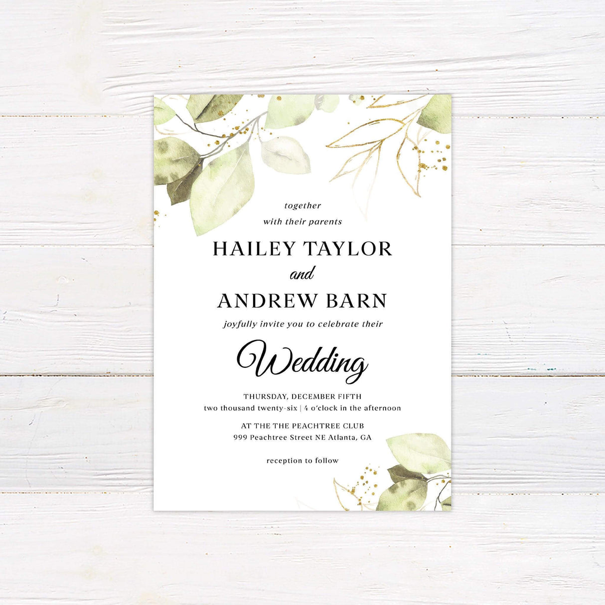 Wedding invitation with gold splatter and green watercolor leaves on white background