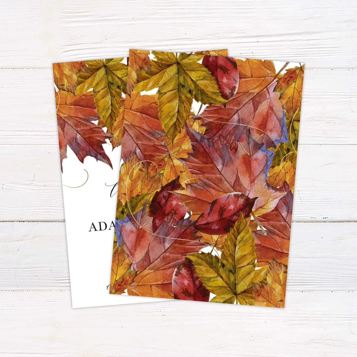 Autumn wedding invitation featuring watercolor red, orange, and gold leaves with elegant calligraphy and serif typography - back