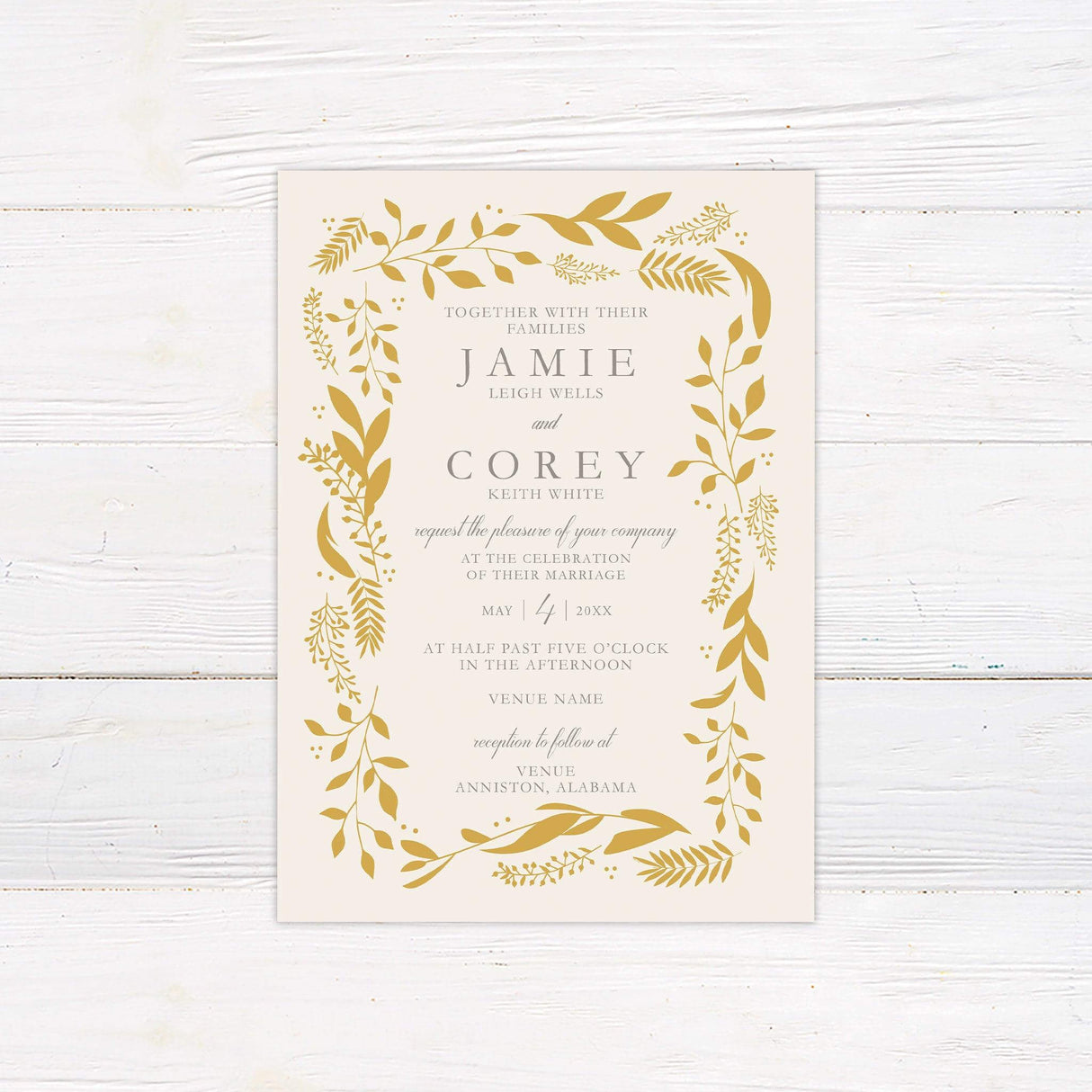 Wedding invitation with golden botanical leaf border, elegant serif and script fonts on ivory background