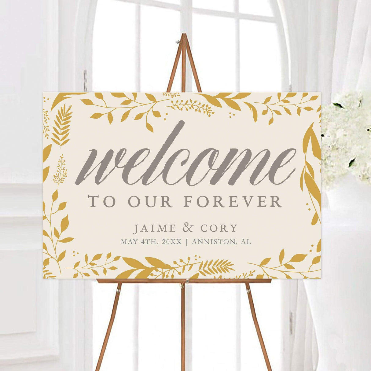 Golden leaves wedding welcome sign featuring a golden botanical leaf border, elegant script lettering, and personalized wedding details. The neutral background and warm foliage create a sophisticated nature-inspired design.