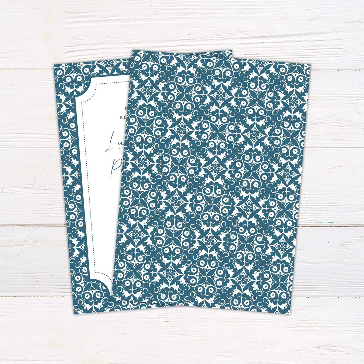 Elegant rehearsal dinner invitation with a white center framed by an ornate blue and white patterned border. Features script and serif fonts detailing event information, including names, date, time, venue, and RSVP details. The classic design conveys sophistication and is perfect for formal pre-wedding celebrations. Back.