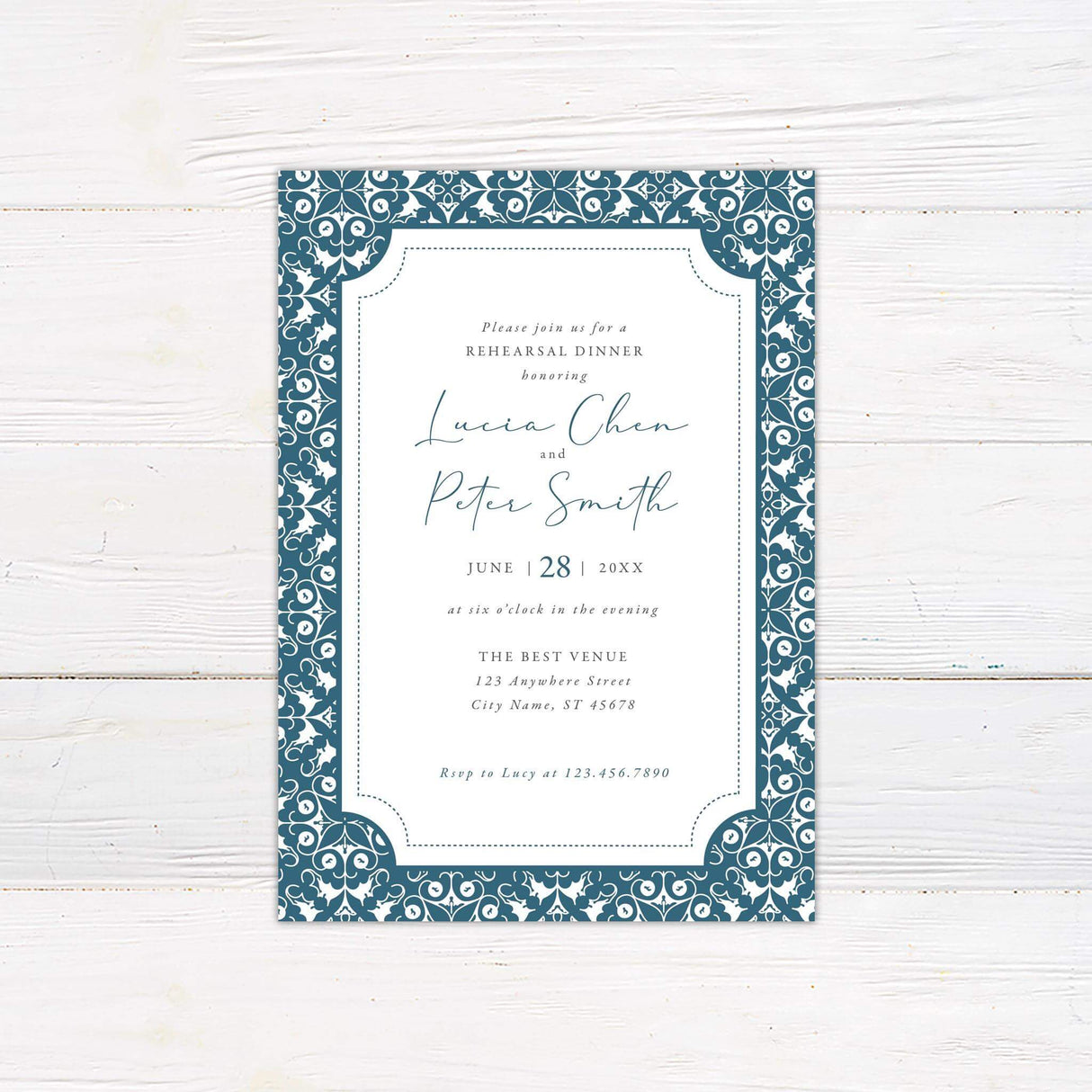 Elegant rehearsal dinner invitation with a white center framed by an ornate blue and white patterned border. Features script and serif fonts detailing event information, including names, date, time, venue, and RSVP details. The classic design conveys sophistication and is perfect for formal pre-wedding celebrations.