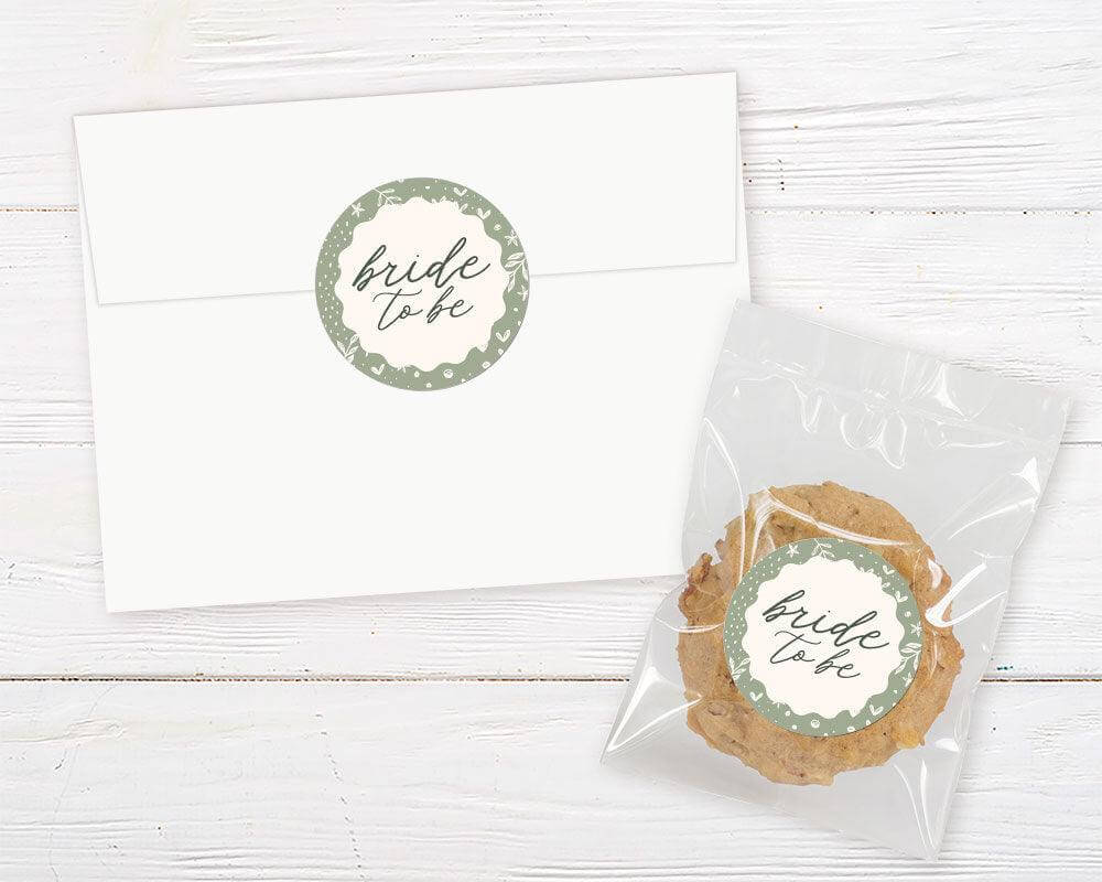 A sage green Green Border Sticker with an arch-shaped center and floral border. The design features botanical accents and elegant script text.