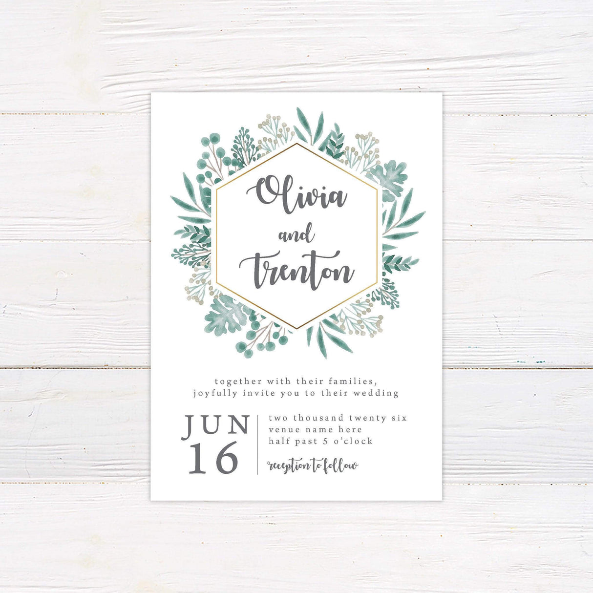 A wedding invitation with a white background features a modern hexagonal frame accented with a gold outline, surrounded by lush watercolor greenery. The couple’s names are displayed in elegant script inside the frame, while the event details, including the date, time, and venue, are arranged in a stylish serif and script font combination below. This design exudes a fresh, botanical feel, perfect for nature-inspired, rustic, or minimalist weddings.