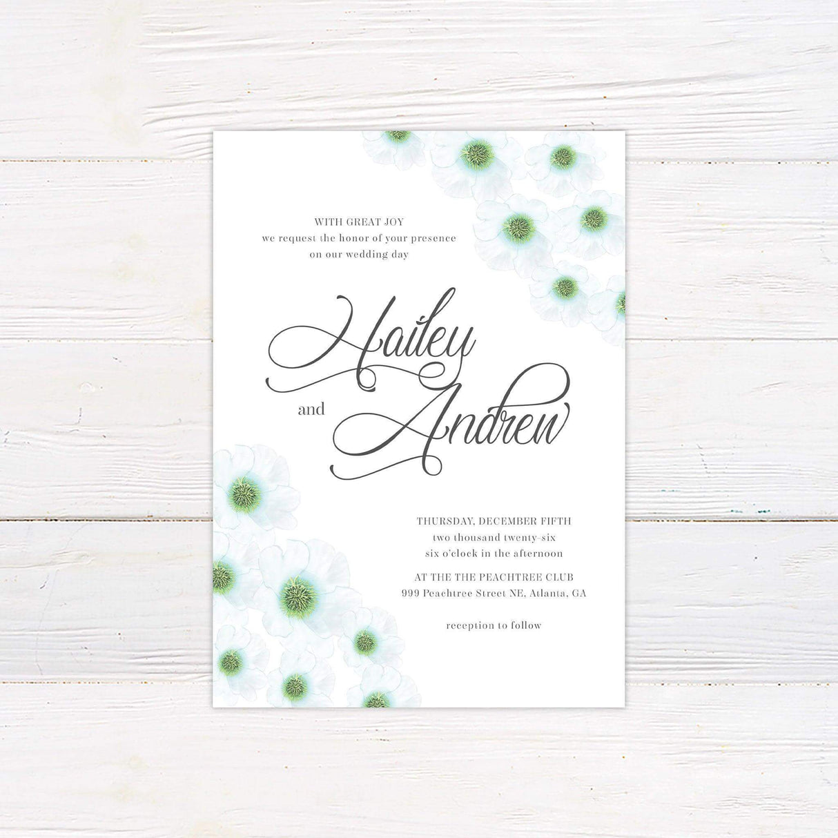 White floral wedding invitation with green-centered anemones and elegant script text on minimalist white background