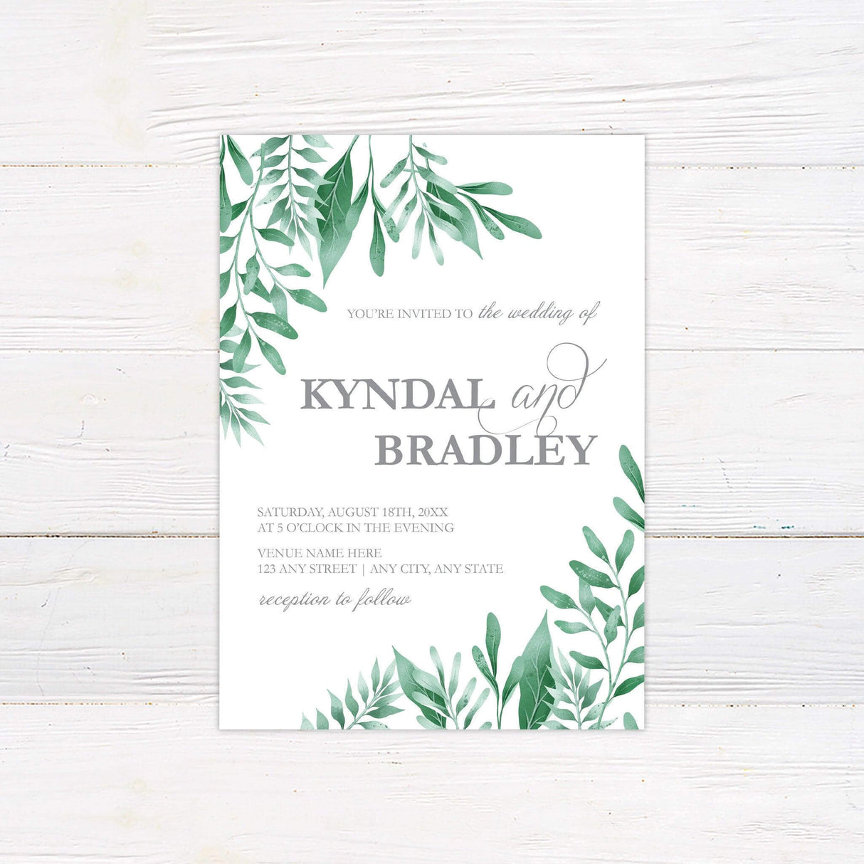 Elegant botanical wedding invitation with watercolor sage green leaves framing the corners and soft script typography on a white background.