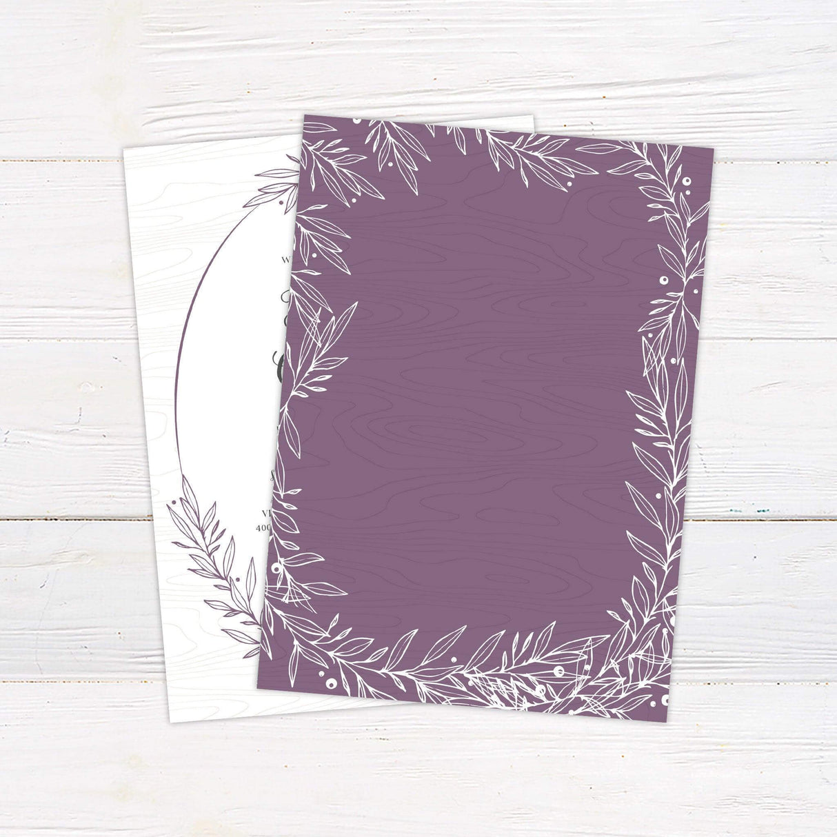 Rustic wedding invitation with hand-drawn botanical wreath, elegant script and serif fonts, and a woodgrain textured background - back