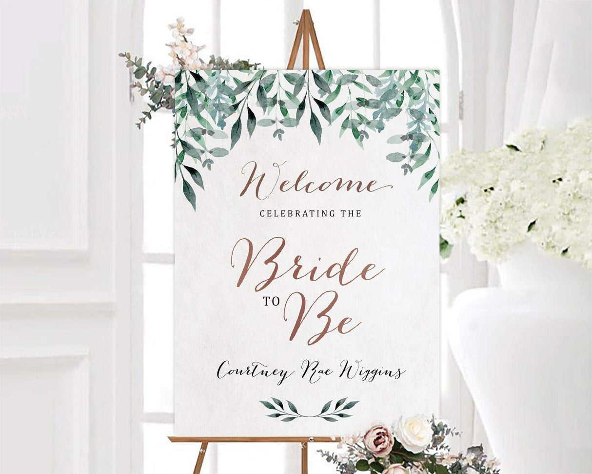 A hanging leaves bridal shower sign with green leafy branches around the edges. The design uses soft neutral colors and elegant script text.