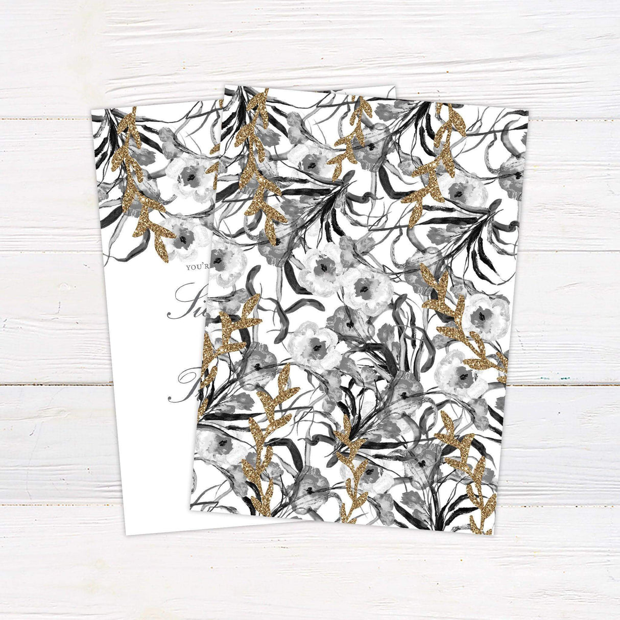 Elegant gold and gray floral watercolor wedding invitation back featuring glitter accents and delicate flower designs, customizable with names, date, and venue