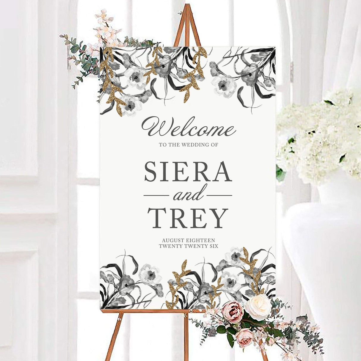 Hint of Gold wedding welcome sign featuring black, gray, and white watercolor florals with elegant gold-inspired botanical accents. The personalized design displays the couple's names and wedding date in classic script and serif typography.