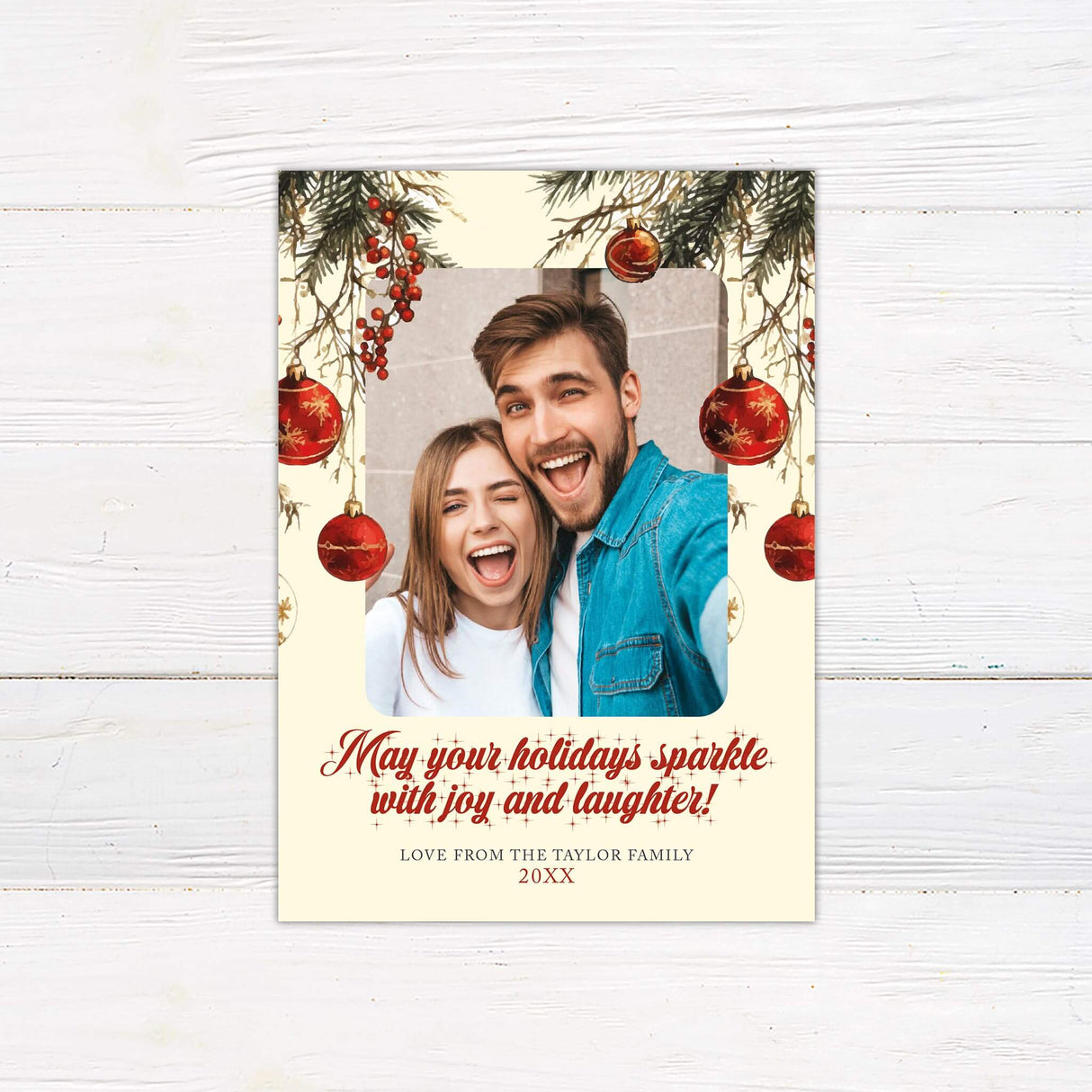 Christmas photo card with pine branches, red ornaments, and a festive family selfie, featuring the text “May your holidays sparkle with joy and laughter!”