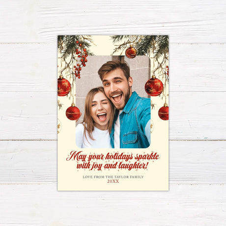 Christmas photo card with pine branches, red ornaments, and a festive family selfie, featuring the text “May your holidays sparkle with joy and laughter!”