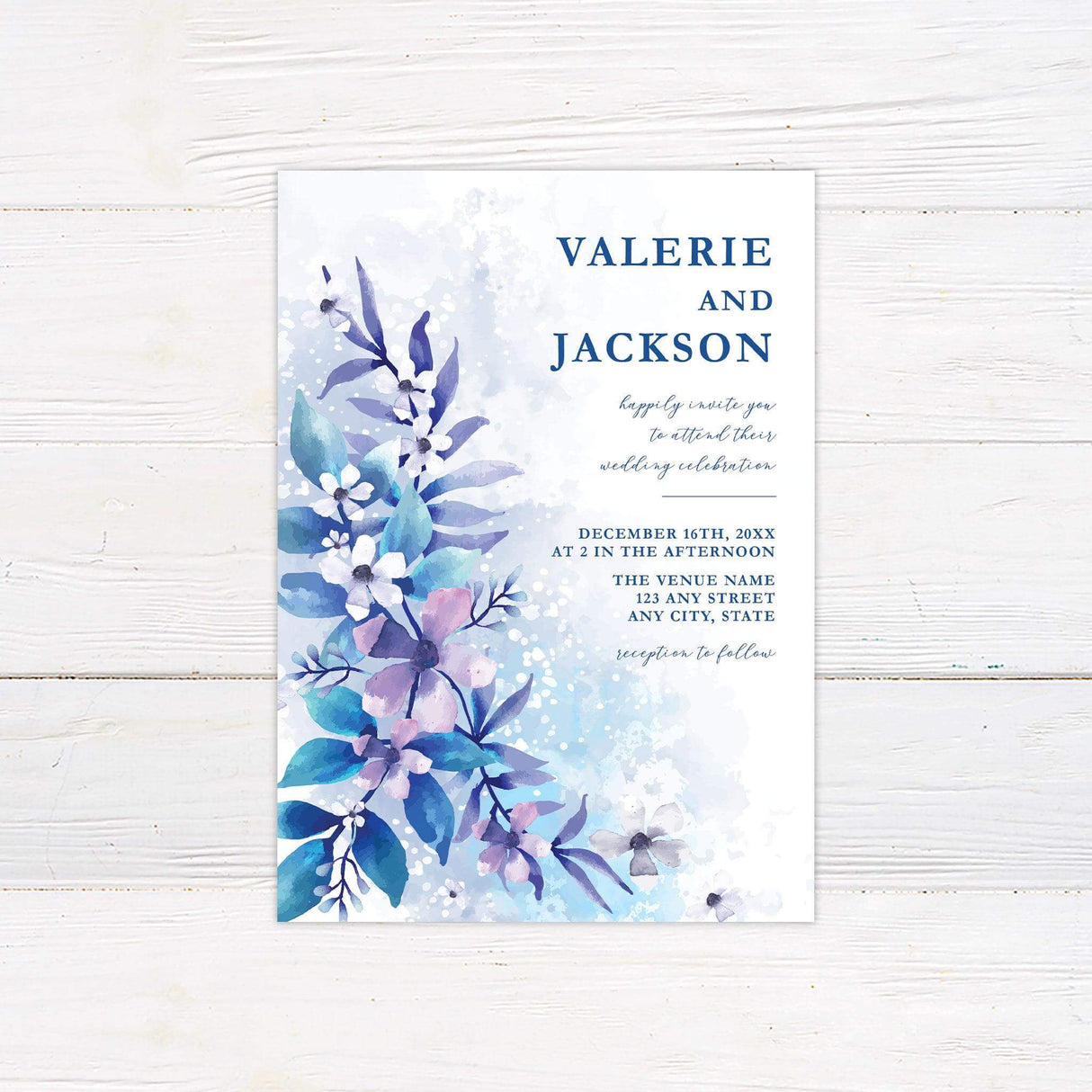 Elegant winter wedding invitation with icy blue and purple watercolor flowers on the left and formal text on the right in a soft winter palette.