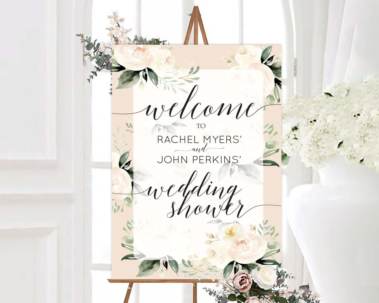 Elegant wedding shower welcome sign featuring ivory peonies, set on an easel in a soft-lit room with white floral decor.