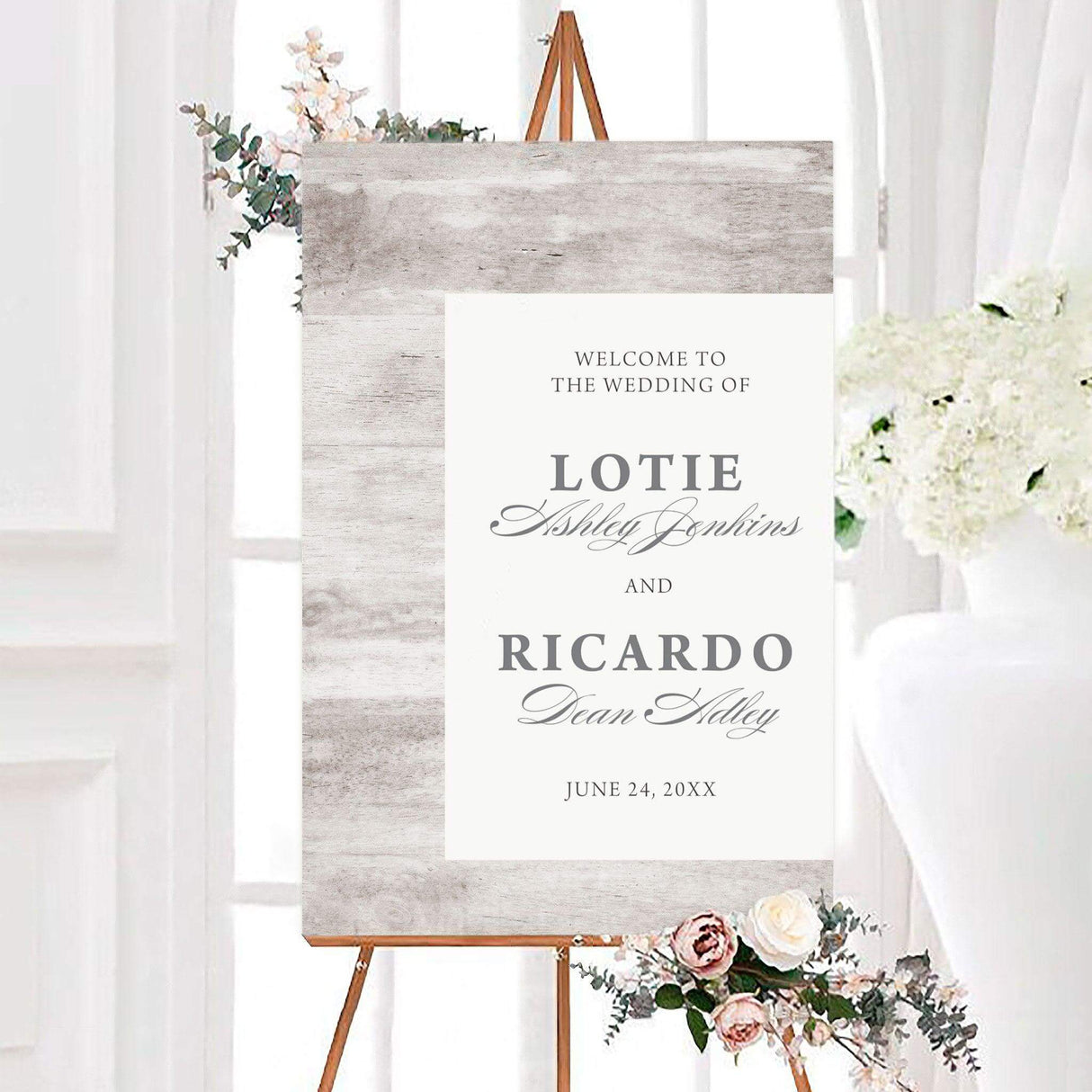 Rustic light wood wedding welcome sign featuring a light weathered wood background, white center panel, and elegant gray typography. The personalized design displays the couple’s names in serif and calligraphy fonts with their wedding date below.