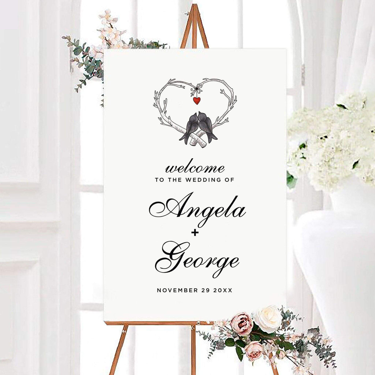Love birds wedding welcome sign featuring two love birds perched beneath heart-shaped branches with a small hanging red heart. Elegant personalized script creates a romantic rustic design for welcoming wedding guests.