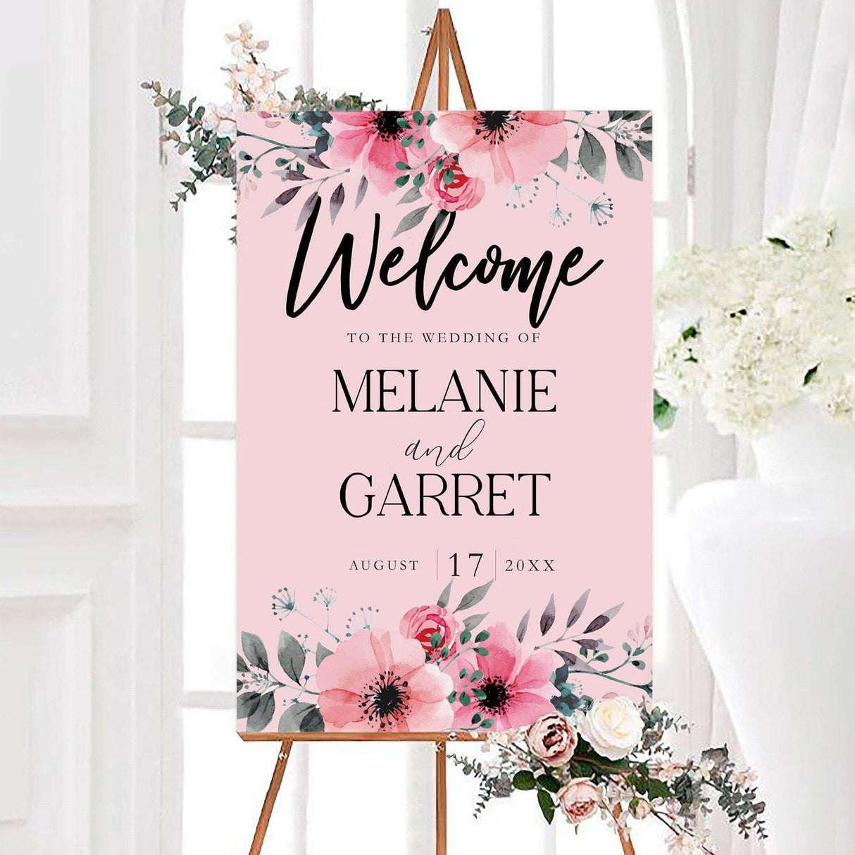 Pink watercolor lovely florals wedding welcome sign with blush, coral, and green botanical accents. The personalized design features the couple’s names and wedding date on a soft blush pink background.