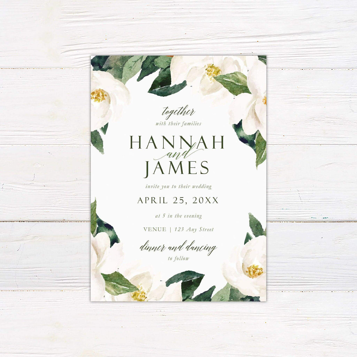 Elegant magnolia wedding invitation with white flowers and green leaves, featuring soft serif and script fonts on a pale background.