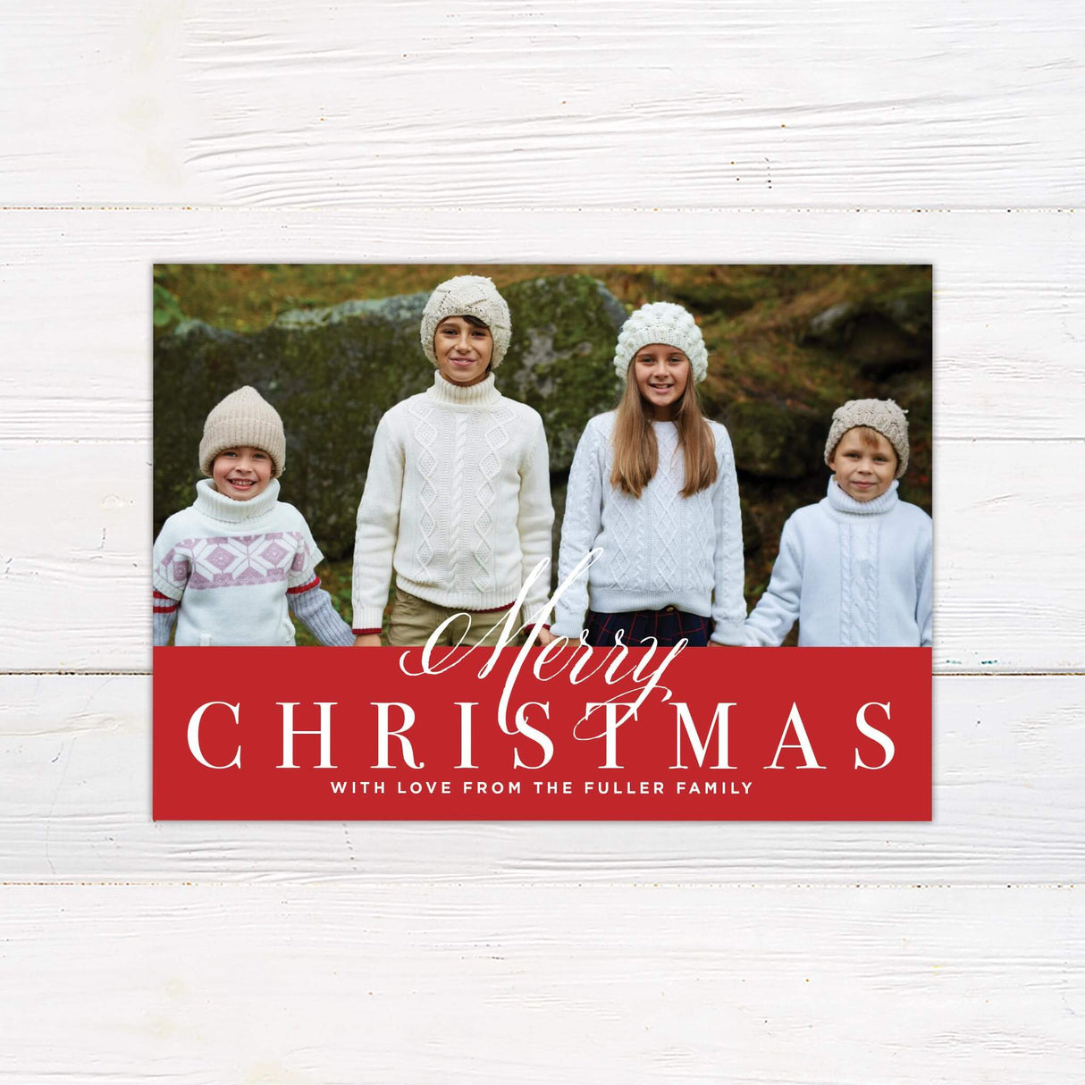 A holiday card design with a large family photo at the top and a bold red section at the bottom featuring the words “Merry Christmas” in elegant fonts.