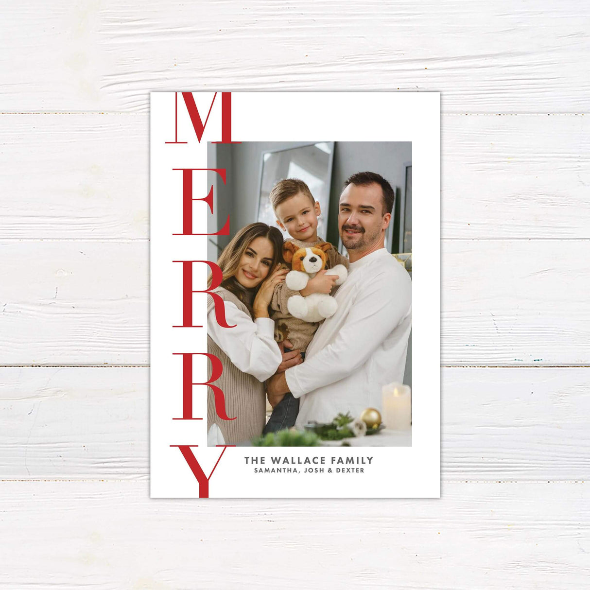 A holiday card design featuring a large customizable family photo on the right with bold vertical "MERRY" text in red on the left.