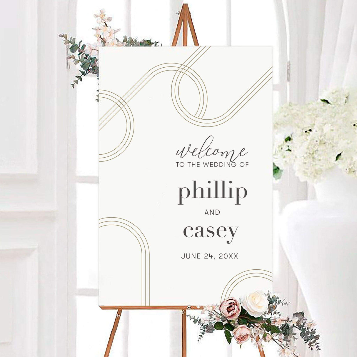 Minimalist geometric curves wedding welcome sign featuring taupe-gold geometric curved lines on a white background with personalized couple names. Modern script and serif typography displays the welcome message and wedding date.