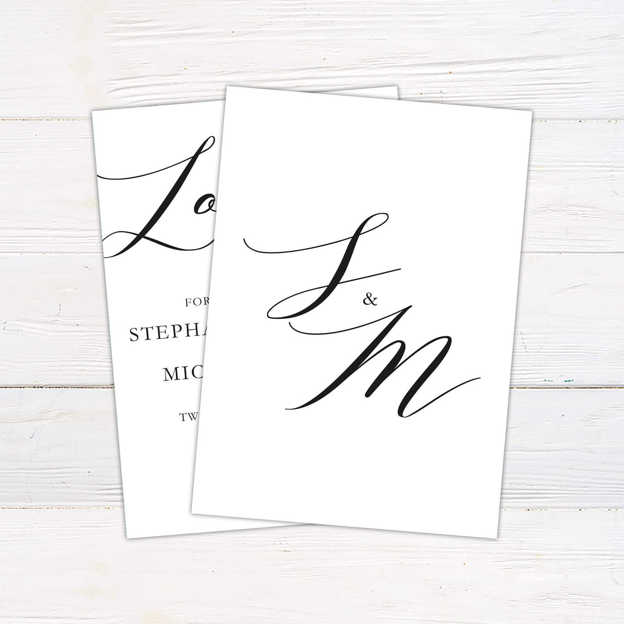 Black and white wedding invitation with large cursive “Love” at the top, modern serif fonts, and elegant wedding details layout - back