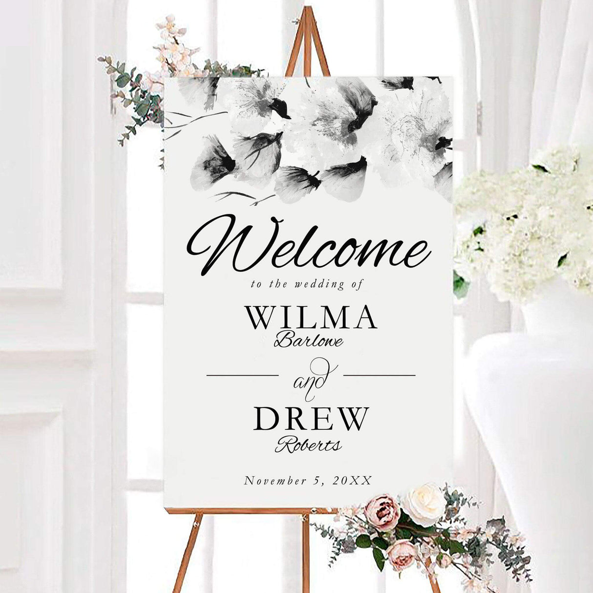 Monochrome big florals wedding welcome sign with large monochrome blossoms and elegant personalized typography. The design features the couple’s names and wedding date with a mix of script and classic serif lettering.