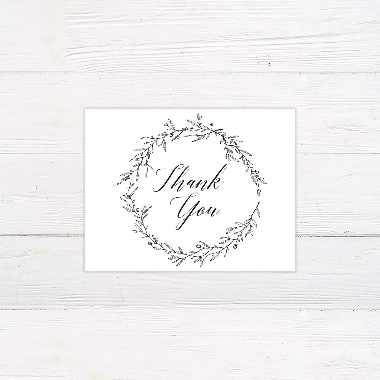 Black and white thank you card with handwritten script and floral wreath design, matching rustic wedding stationery set.