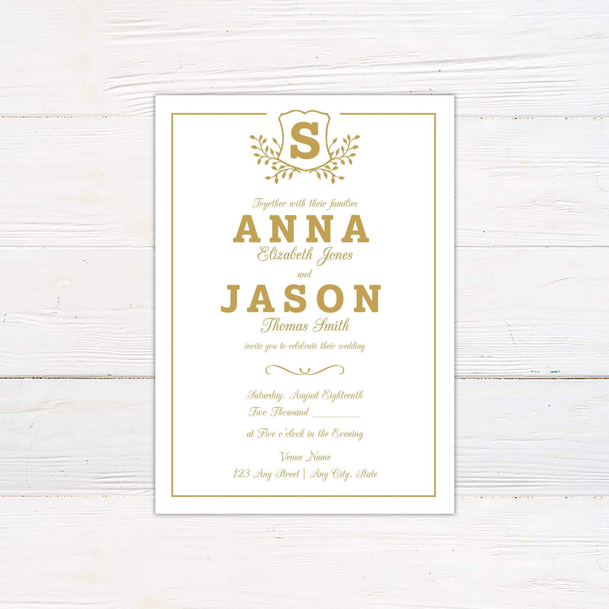 Gold wedding invitation with monogram shield crest, bold serif names, elegant script details, and formal layout with border on white background