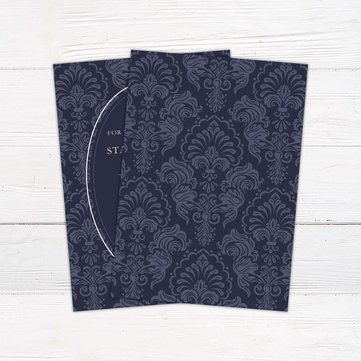 Navy wedding invitation with white oval frame, vintage damask background, and elegant serif fonts in a formal layout - back side