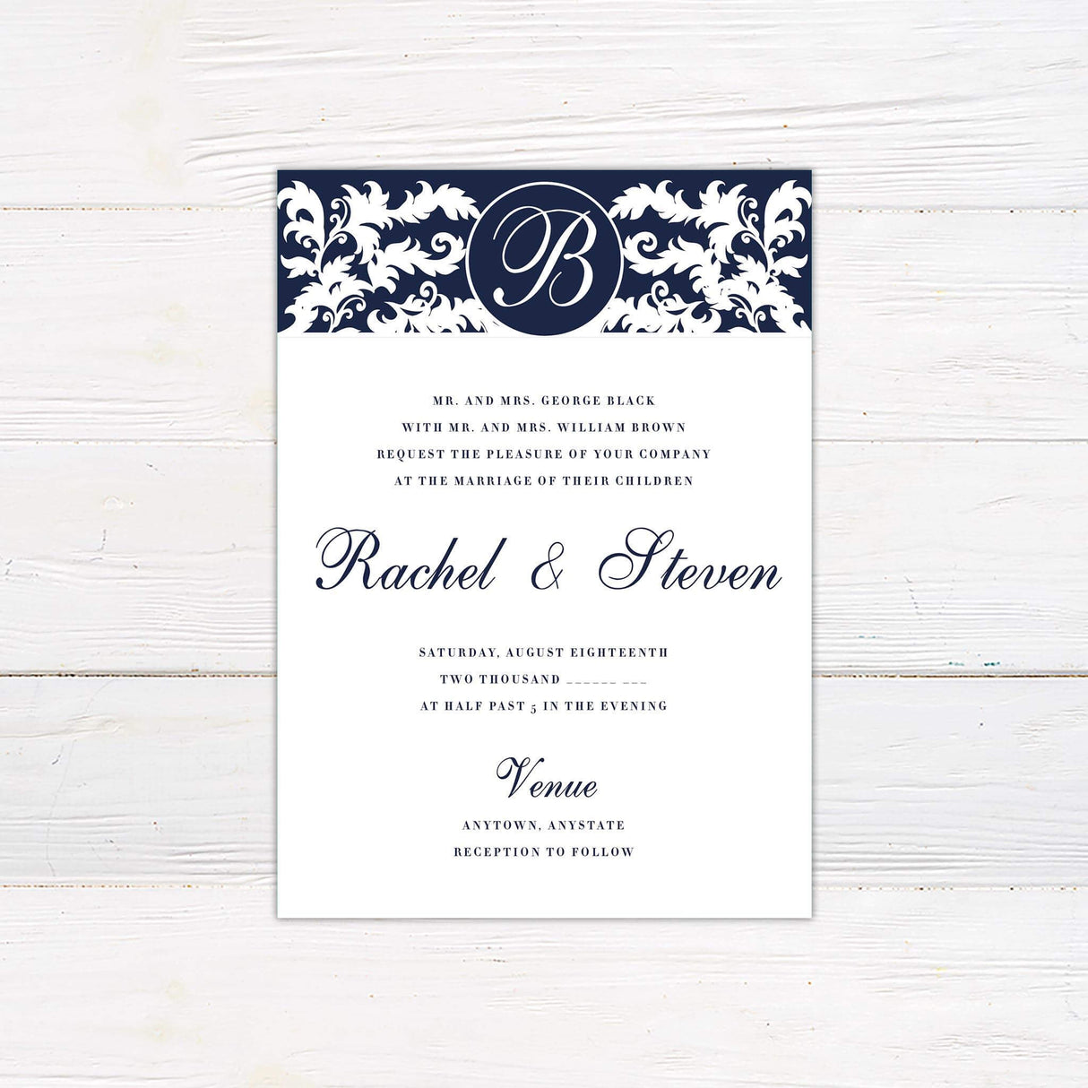 Navy and white damask wedding invitation with monogram crest and elegant script names, printed on white cardstock.