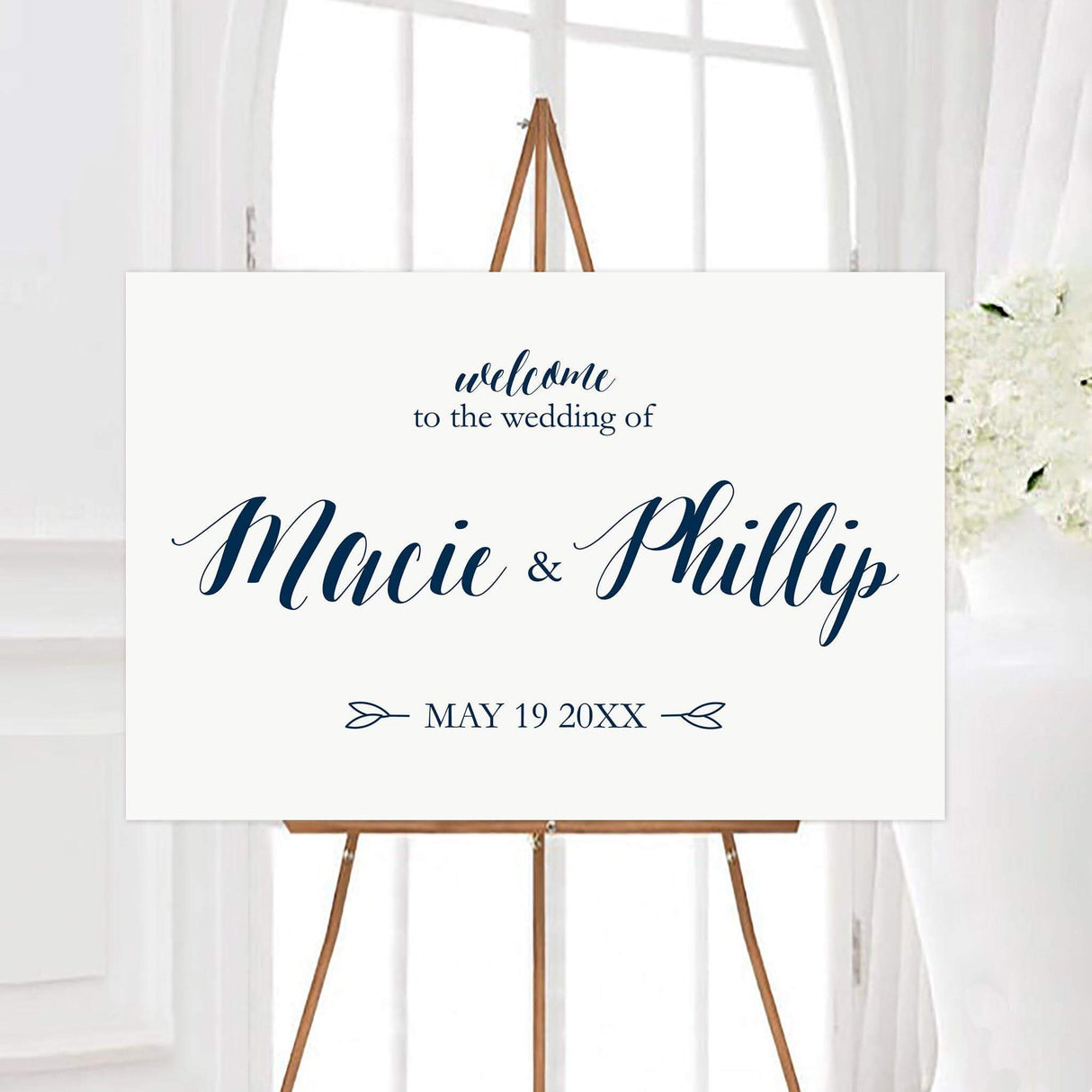 Minimalist navy and white wedding welcome sign with elegant navy script lettering on a clean white background. The personalized design features the couple’s names, wedding date, and small botanical accents.