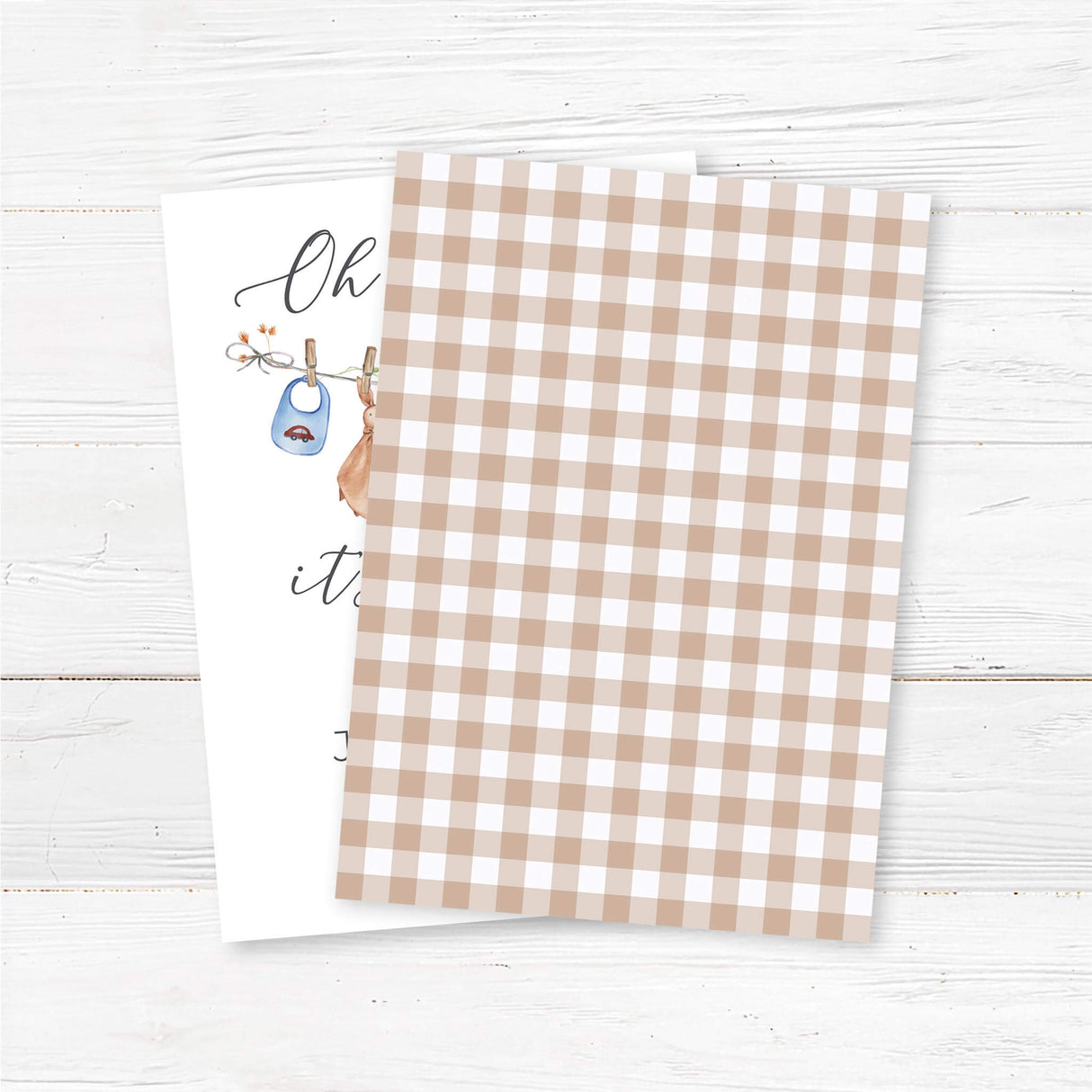 Printed baby shower invitation featuring a watercolor baby clothesline with adorable blue baby outfits, bibs, and socks. The text reads 'Oh Baby, It's a Boy!' in an elegant script font. Perfect for a rustic, boho, or vintage baby shower. Customizable with honoree’s name, date, time, and location. Printed on thick premium cardstock and includes envelopes. Ideal for a gender reveal, baby sprinkle, or classic boy baby shower theme back