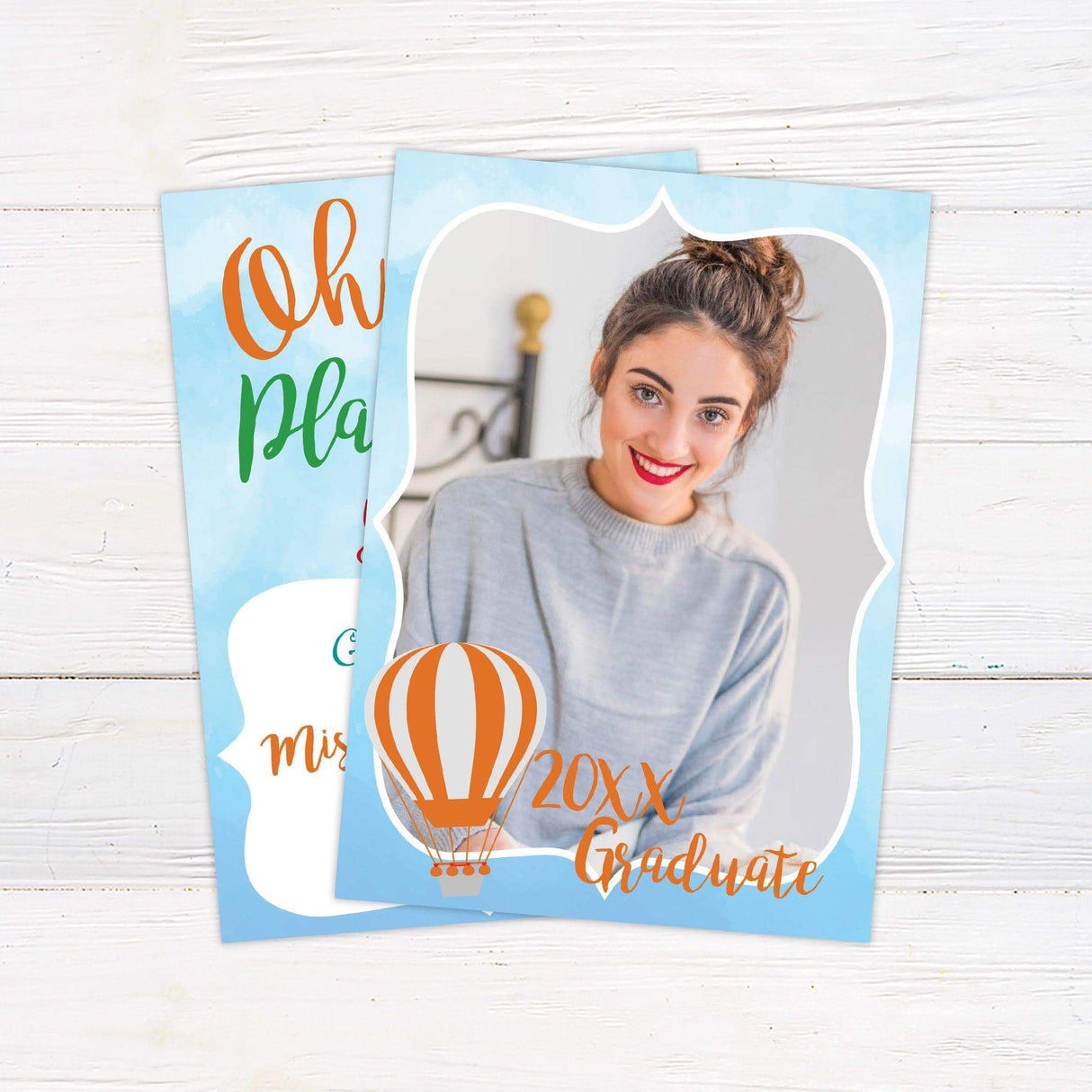 Graduation announcement with a light blue watercolor border featuring a photo of the graduate, a hot air balloon, and bold script text reading "20XX Graduate." A celebratory design perfect for announcing a milestone achievement.